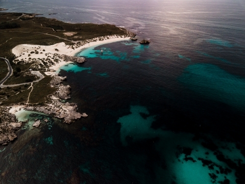 horizontal shot of an island with white sand beach, trees, and grass on a sunny day - Australian Stock Image