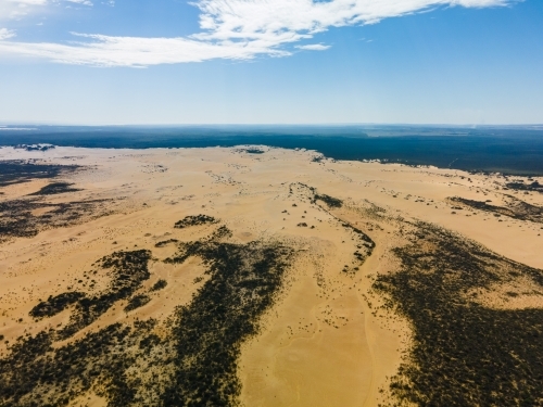 horizontal shot of an outback near the ocean with green bushes on a sunny day with cloudy skies - Australian Stock Image