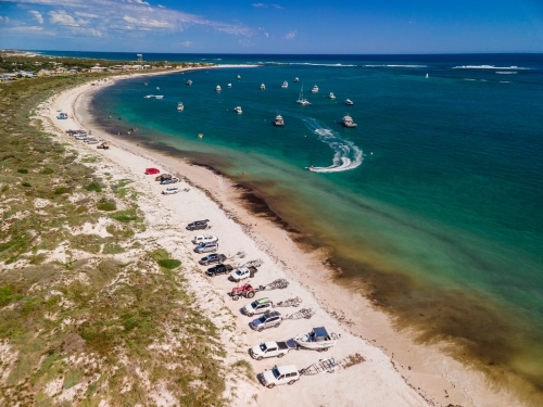 horizontal shot of cars and boats parked on a white sand with bushes and running boats - Australian Stock Image