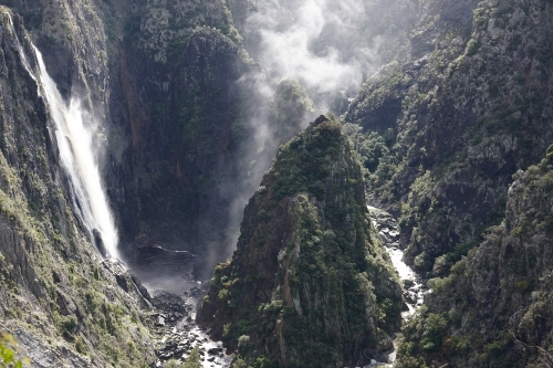 Horizontal shot of foggy ravine and waterfall from cliff - Australian Stock Image