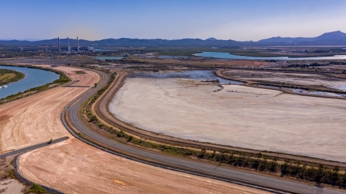 Horizontal shot of highway out of Gladstone with Mount Larcom in the background - Australian Stock Image