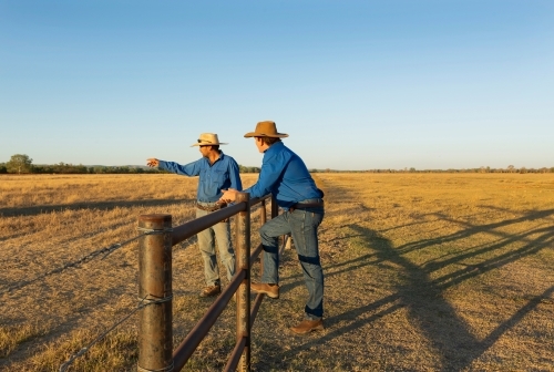 Horizontal shot of two men talking while mustering cattle - Australian Stock Image