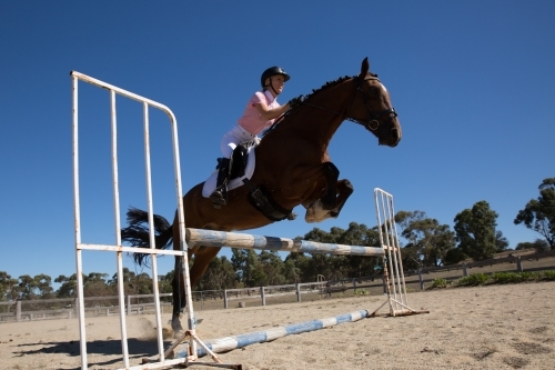 Horse and rider show Jumping in sand arena - Australian Stock Image