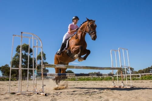 Horse and rider show Jumping in sand arena - Australian Stock Image