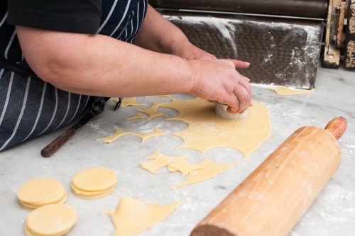 Hospitality worker cutting pastry in circles