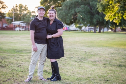 Husband and wife standing close together smiling - Australian Stock Image