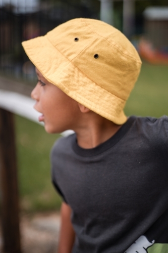 Iconic bucket hat worn by young Aboriginal boy at preschool - Australian Stock Image