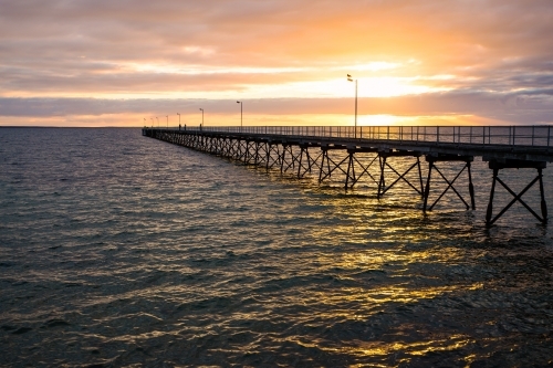 Jetty silhouetted against sunset - Australian Stock Image