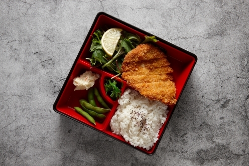 Katsu bento box with rice, meat, and vegetables - Australian Stock Image