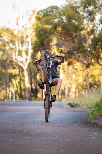 kid doing a wheelie on his mountain bike - Australian Stock Image