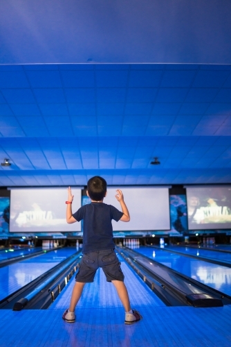 Kids 10 pin bowling under blue lights - Australian Stock Image