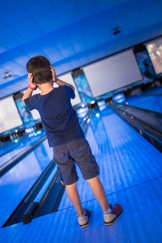 Kids 10 pin bowling under blue lights - Australian Stock Image