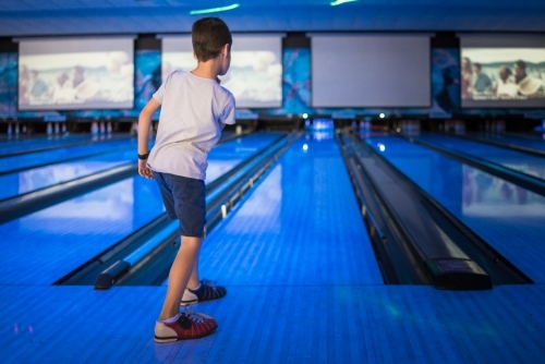 Kids 10 pin bowling under blue lights - Australian Stock Image