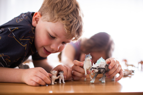 kids playing with animal figurines - Australian Stock Image