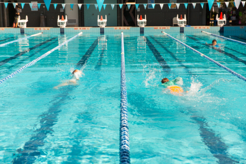 kids swimming in the lanes of an outdoor 25 metre pool - Australian Stock Image