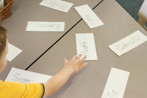 Kindergarten child finding his name - Australian Stock Image