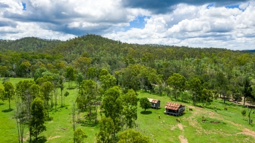 Kroombit Tops National Park summer landscape with disused homestead and vibrant green vegetation, Qu - Australian Stock Image