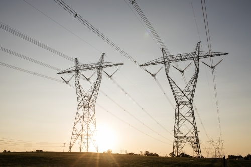 landscape of powerlines with sunset in background. - Australian Stock Image
