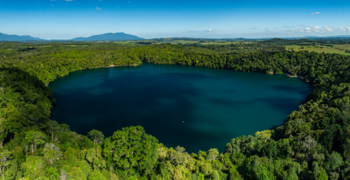landscape of rainforest and deep blue lake - Australian Stock Image
