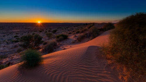 Landscape of sand dunes in desert at sunset - Australian Stock Image