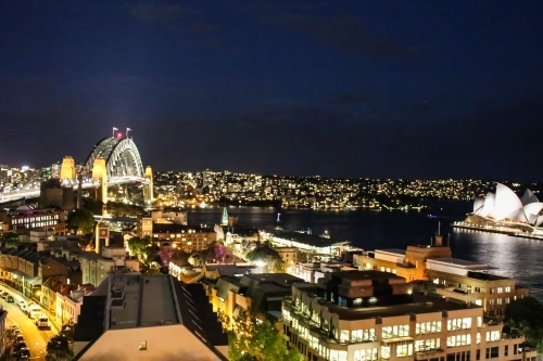 Landscape view of Sydney Harbour Bridge and Sydney Opera House with lights at night - Australian Stock Image