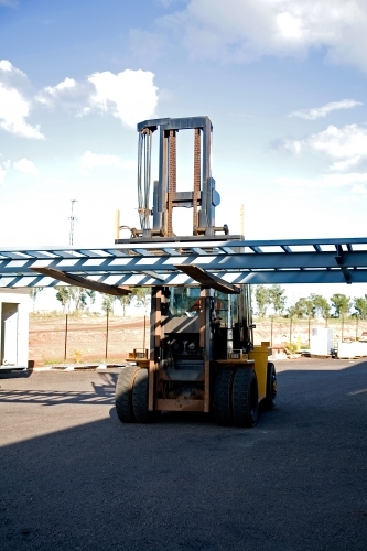 Large forklift carrying metal framework on a work site - Australian Stock Image