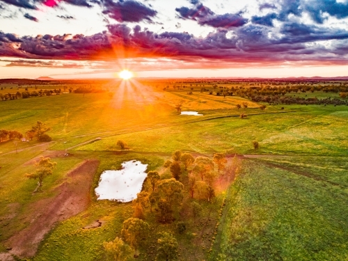 Last rays of sunlight over farmland and dam - Australian Stock Image