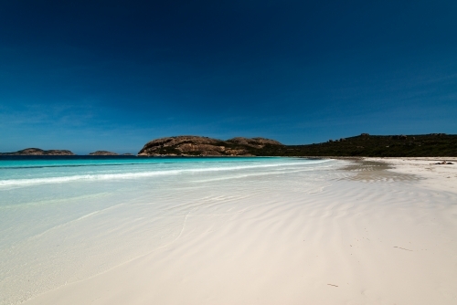 Leading lines on a white sand beach with beautiful clear shore line and deep blue polarised - Australian Stock Image