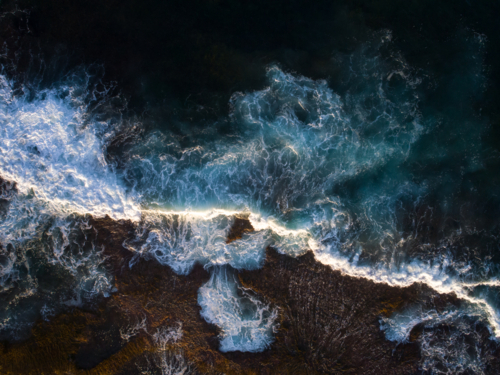 Light captures a breaking wave in the early morning - Australian Stock Image