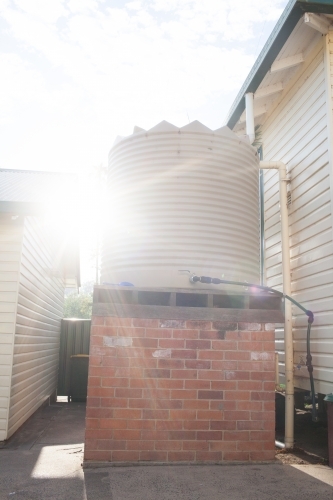 Light flare on a backyard water tank - Australian Stock Image