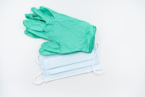 Light green gloves and surgical mask flatlay - Australian Stock Image