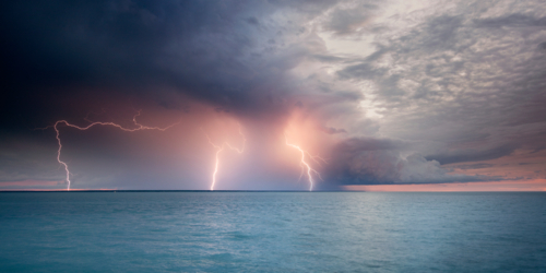 Lightning offshore, sunset storm over Darwin Harbour - Australian Stock Image