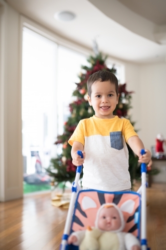 Little boy opening Christmas presents at home - Australian Stock Image