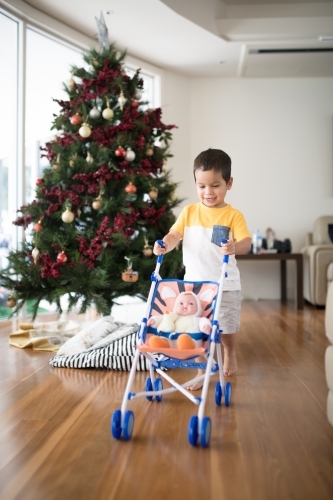 Little boy opening Christmas presents at home - Australian Stock Image