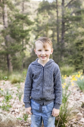 Little boy standing in front of trees - Australian Stock Image