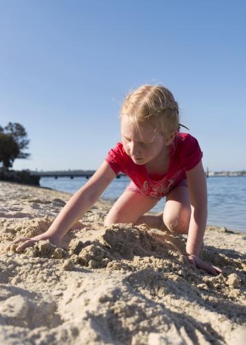 Little Girl Digging In The Sand - Australian Stock Image