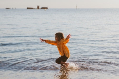 Little girl running in the beach - Australian Stock Image