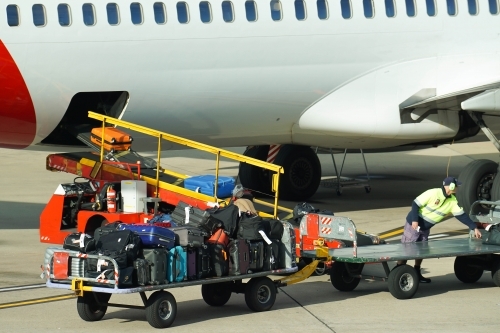 Loading baggage onto airplane - Australian Stock Image
