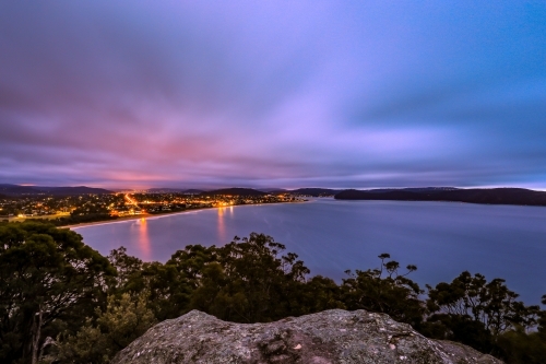 Long exposure over ocean and city night lights - Australian Stock Image