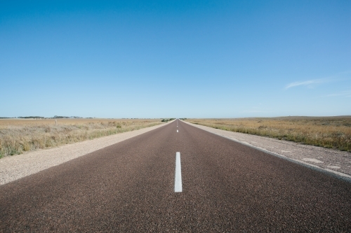 Long straight empty road through rural land - Australian Stock Image