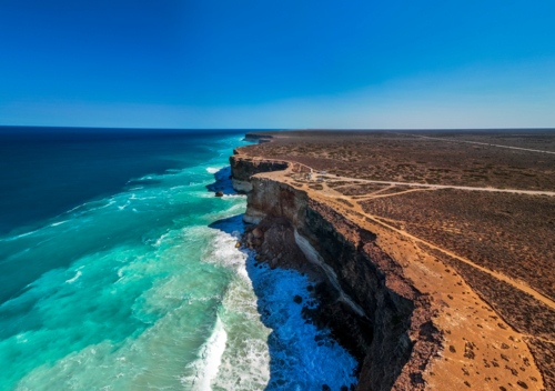 Long stretch of towering cliffs with deep turquoise waters. - Australian Stock Image