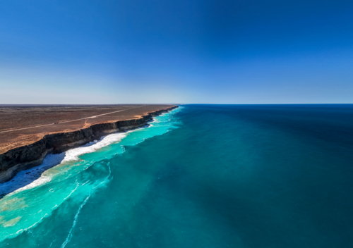 Long stretch of towering cliffs with deep turquoise waters - Australian Stock Image