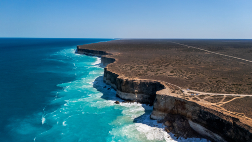 Long stretch of towering cliffs with deep turquoise waters. - Australian Stock Image