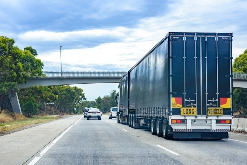 Long vehicle following traffic flow on Macorna st, Watsonia - Australian Stock Image