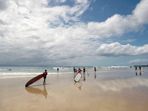 Longboard surfers walking to a surf break