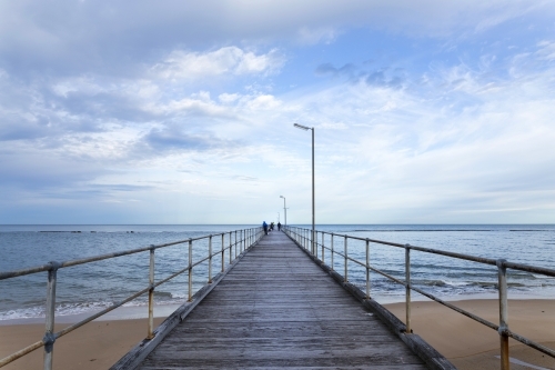 Looking along a jetty with people out fishing - Australian Stock Image