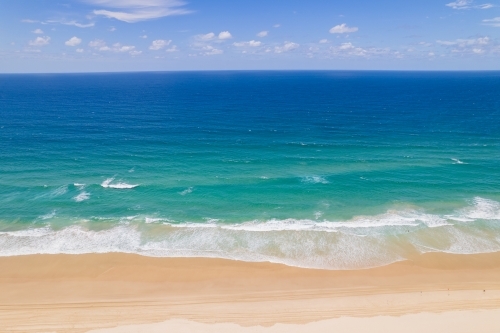 Looking at the simple colours of ocean, beach and sand from above - Australian Stock Image