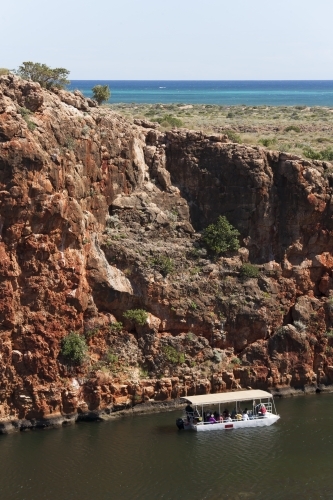 Looking down from cliff to tourist boat in remote gorge