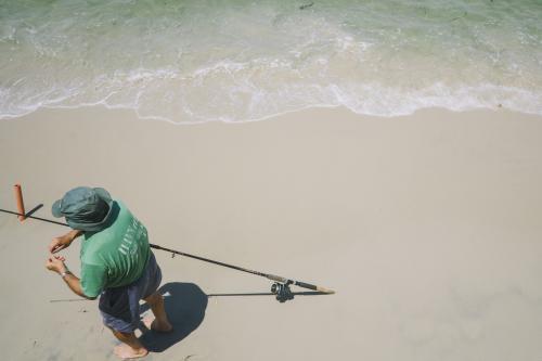 looking from above a fisherman preparing his line with bait - Australian Stock Image