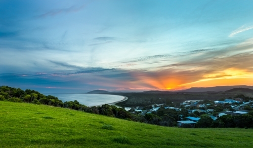 Looking out across a coastal town and bay at sunset - Australian Stock Image